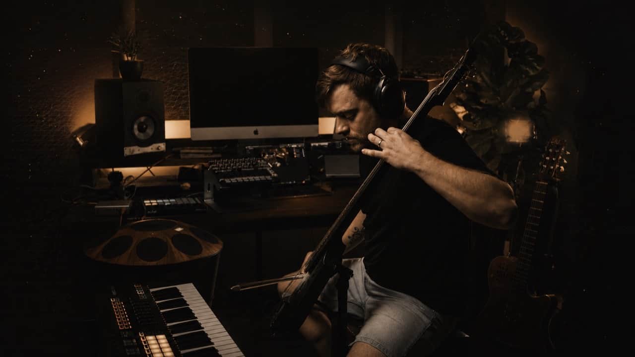 Reinhardt Buhr in his studio with handpan, cello, and keyboard